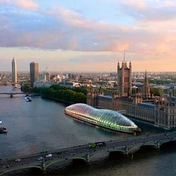 A bridge over a river with a city in the background.