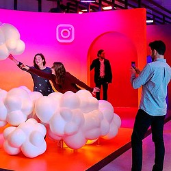 A group of people on a stage with balloons.