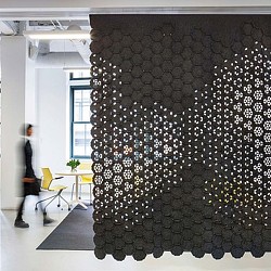 A person standing in a room with a wall of lights.