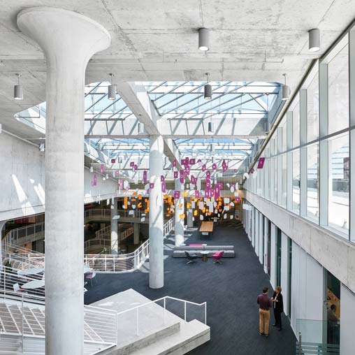 A large room with a few people and a large white structure.