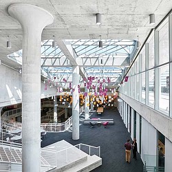 A large room with a few people and a large white structure.