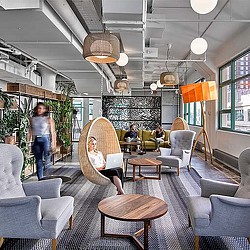 A person standing in a room with a table and chairs.