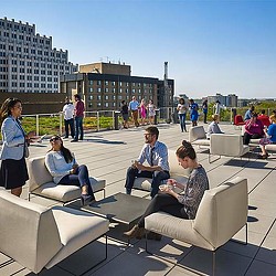 A group of people sitting on chairs outside.