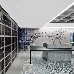 A room with a bench and a wall with art on it.