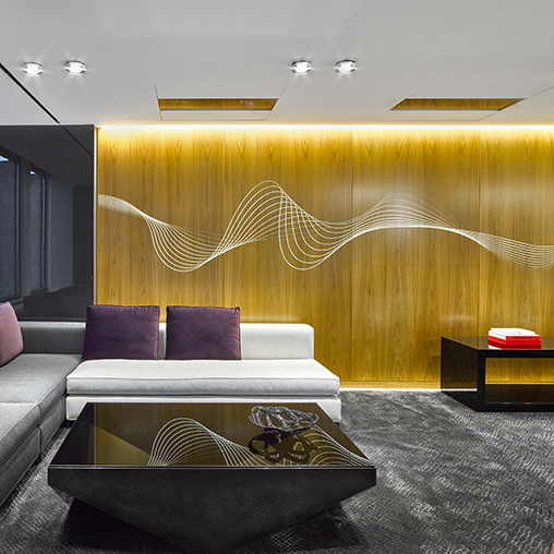 A room with a couch and a table with a wall with art.