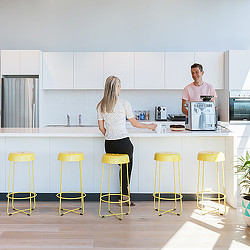 A man and woman in a kitchen.