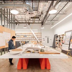 A person standing next to a table with objects on it.