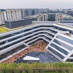 A group of buildings with a green field in front of them.