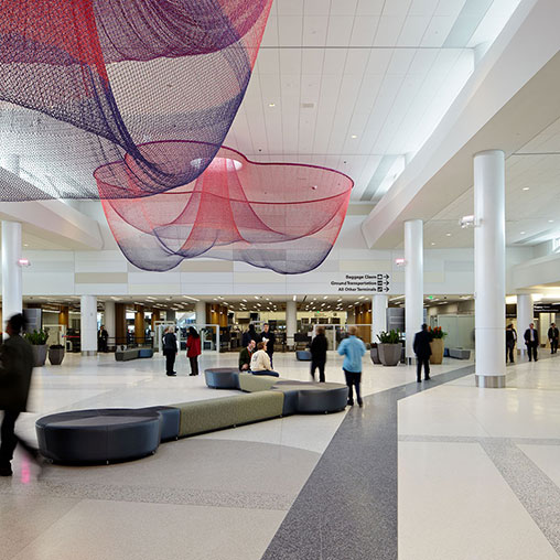 A large building with people and a large pink and purple ceiling.