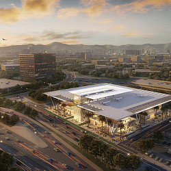 A large building with a parking lot and a large city in the background.