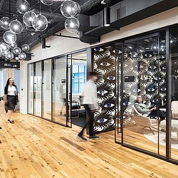 A man and woman in a room with glass doors and a glass wall.