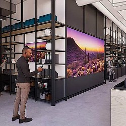 A man standing in front of a large screen.