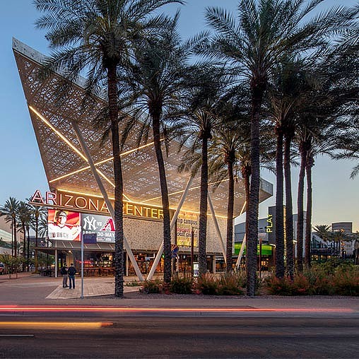 A building with palm trees in front of it.