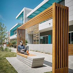 A person sitting on a bench outside a building.