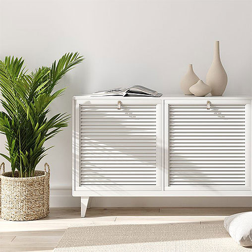 A white radiator with a plant and a basket on the side.