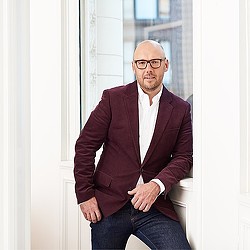 A man sitting on a window ledge.