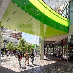 People walking under a green awning.