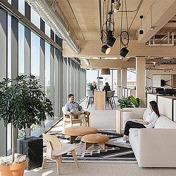 A man and woman sitting in a room with a table and chairs.