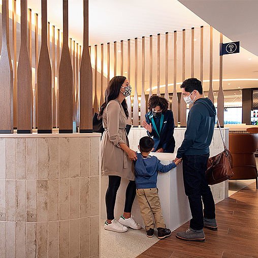 A group of people standing in a room with a person and a child.