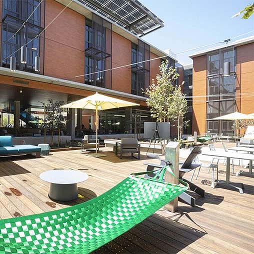 A patio with tables and chairs outside of a building.