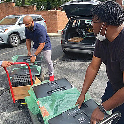 A man pushing a cart with a man in it.