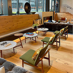 A room with a couch chairs and tables.