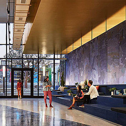 A group of people sitting on a bench in front of a gate.