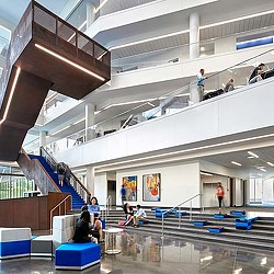 A group of people sitting on the stairs of a building.
