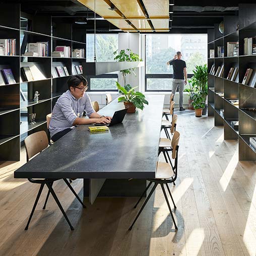 A person sitting at a table in a library.