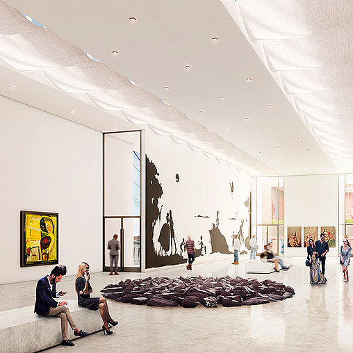 People sitting on a bench in a large room with art on the walls.
