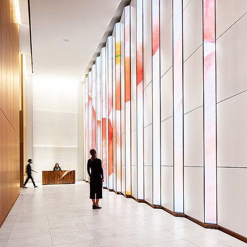 A person and a child walking in a hallway.