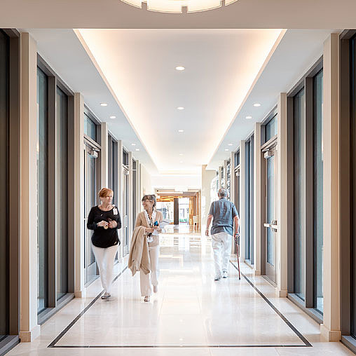 A few people walking through a hallway.