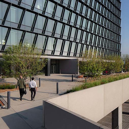 A couple of people walking outside of a building.