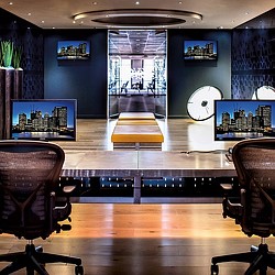 A room with a large screen and chairs.