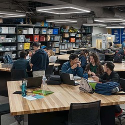A group of people sitting at desks in a library.