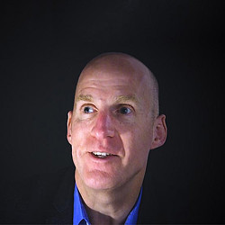 A bald man with a blue shirt.