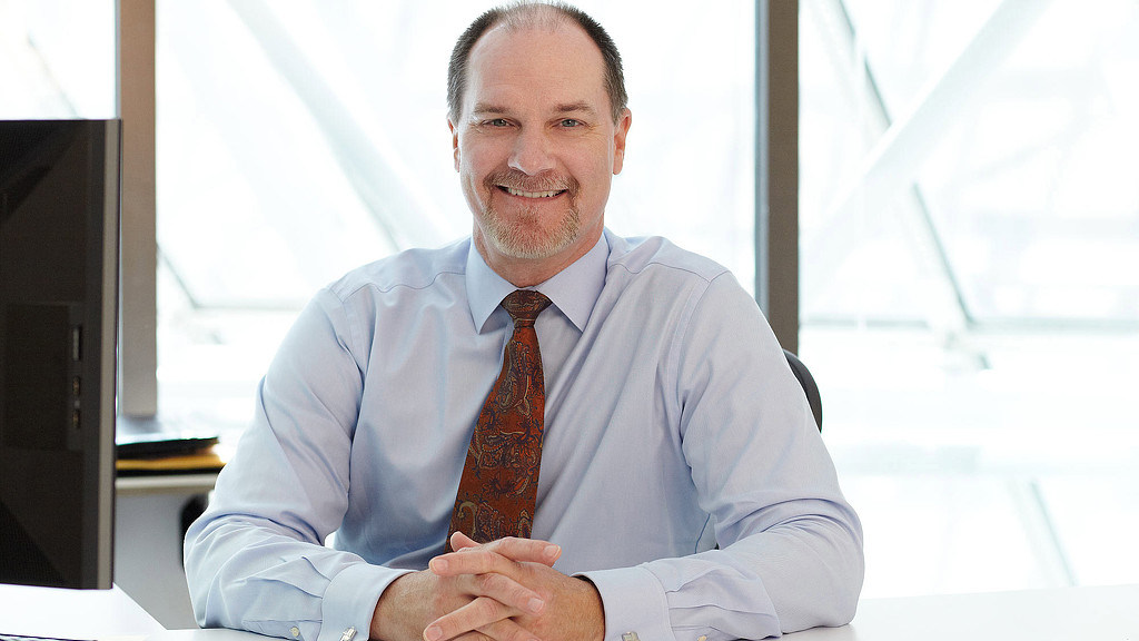 A man in a white shirt and tie with his arms crossed.