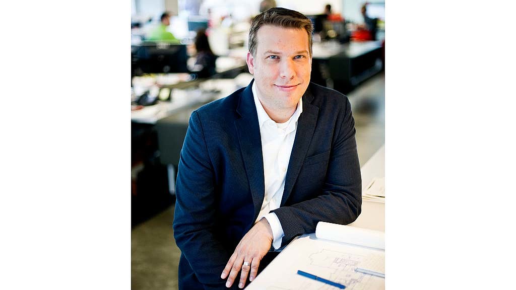 A man in a suit sitting at a desk.