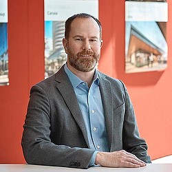 A man with a beard sitting at a table.