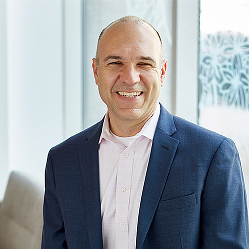 A man in a suit smiling.