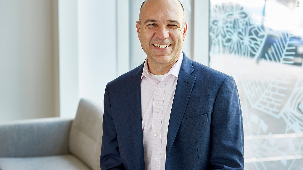 A man in a suit smiling.