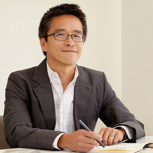 A man wearing glasses and a suit.