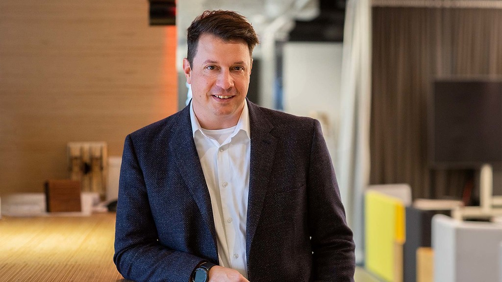 A man in a suit smiling.