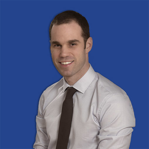 A man in a tie smiling.