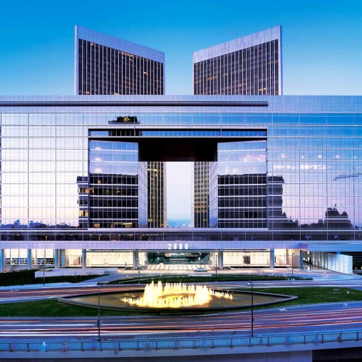 A large building with a pool in front of it.
