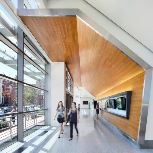 A couple of women walking down a walkway between buildings.