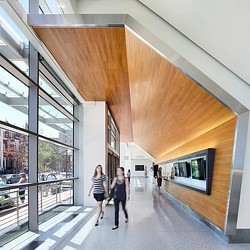A couple of women walking down a walkway between buildings.