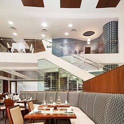 A room with a table chairs and a large window.