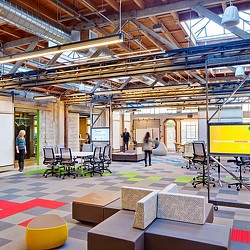 A room with a few people and computers.