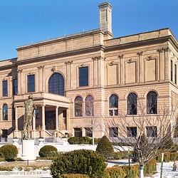A large building with a statue in front of it.